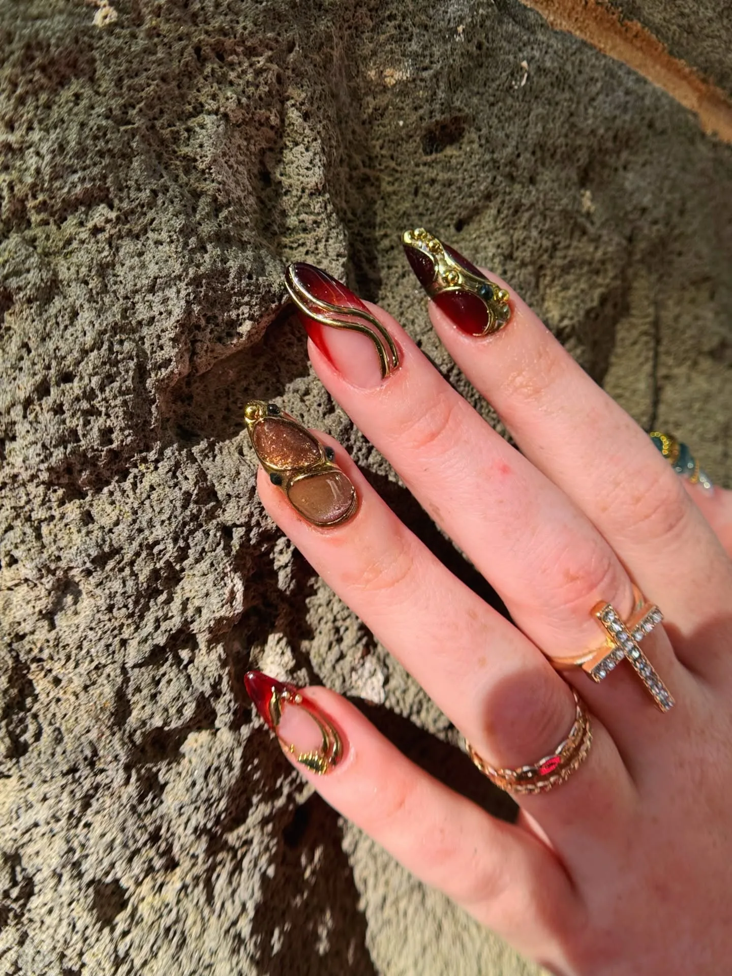 Blood-red and gold-foil ornate stiletto nails