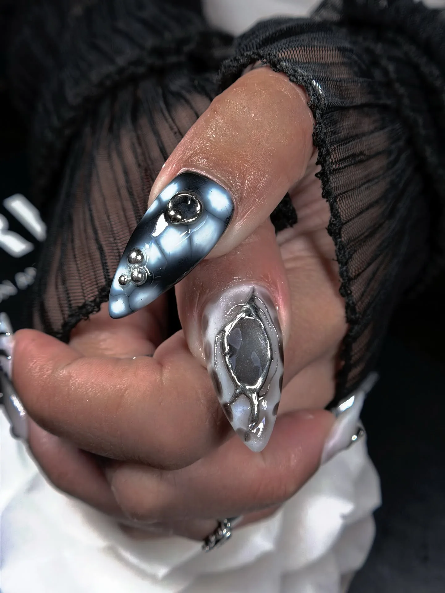 Blue and silver chrome 3D nails with metal beads on black mesh sleeve