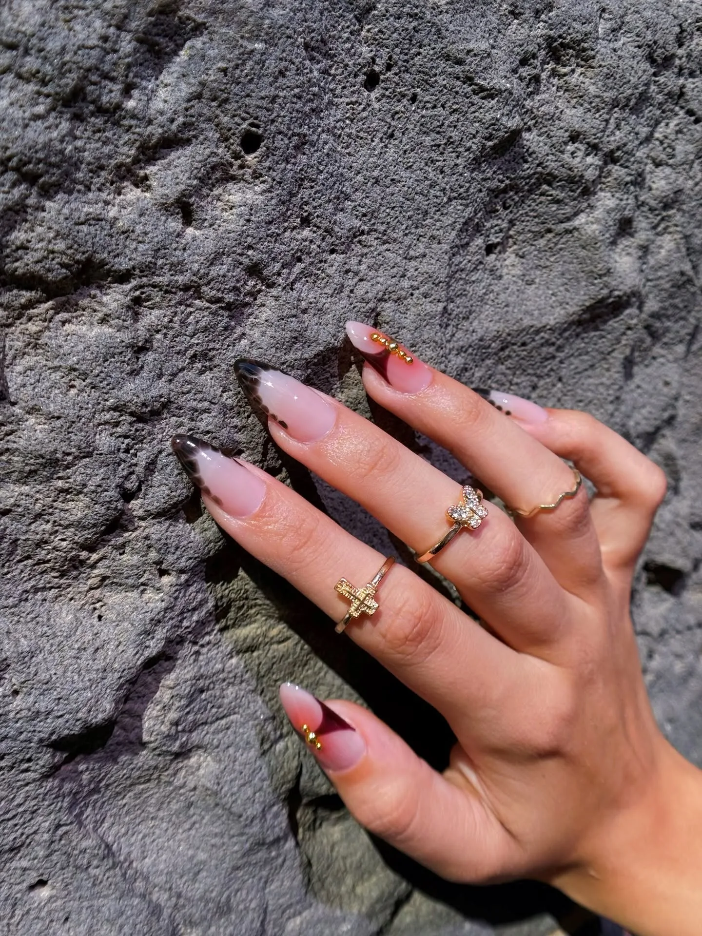 Nude nails with soft black smoke tips and gold beads