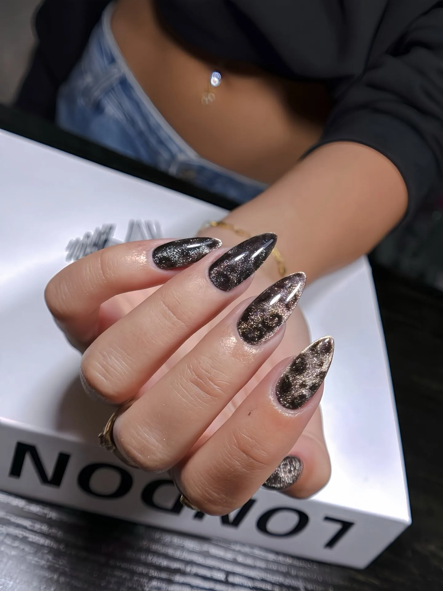 Black and gold glitter cat-eye stiletto nails
